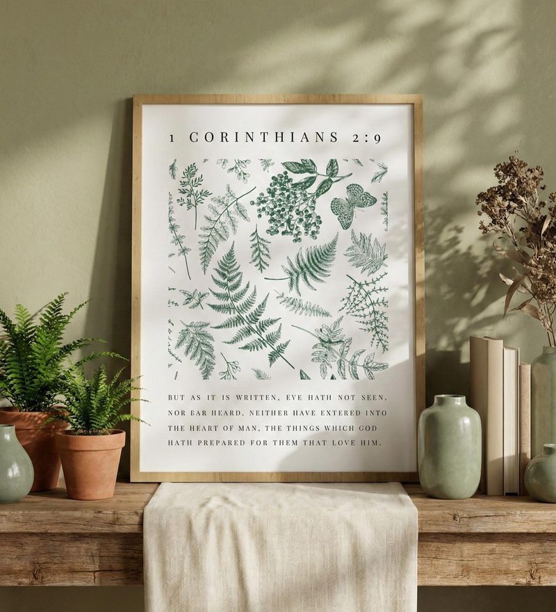 1 Corinthians 2:9 KJV fern wall art — the print in a red oak frame, on a sideboard with potted ferns